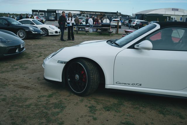 A white Porsche 911 convertible, low and close.