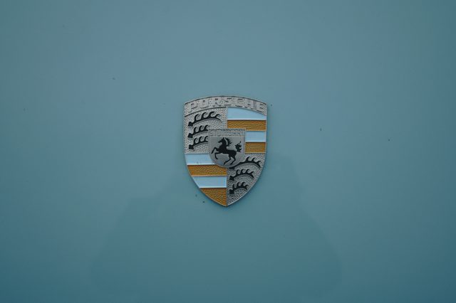 The Porsche crest on pale blue paint.