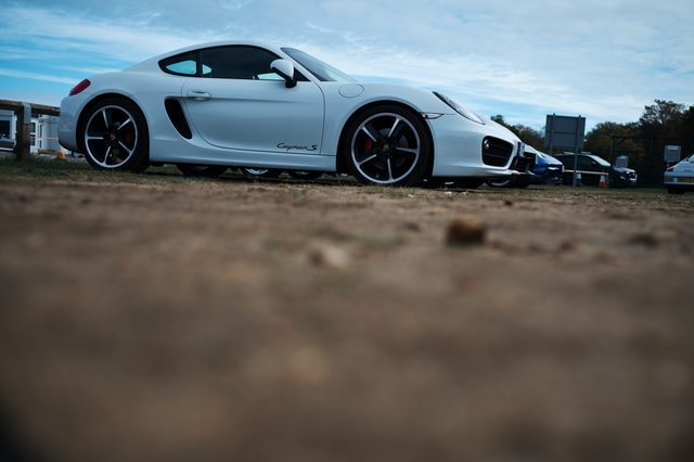 A white Porsche side on, shot low across the gravel.
