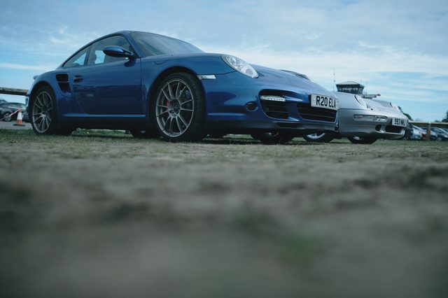 A blue Porsche 911 seen low across the ground.