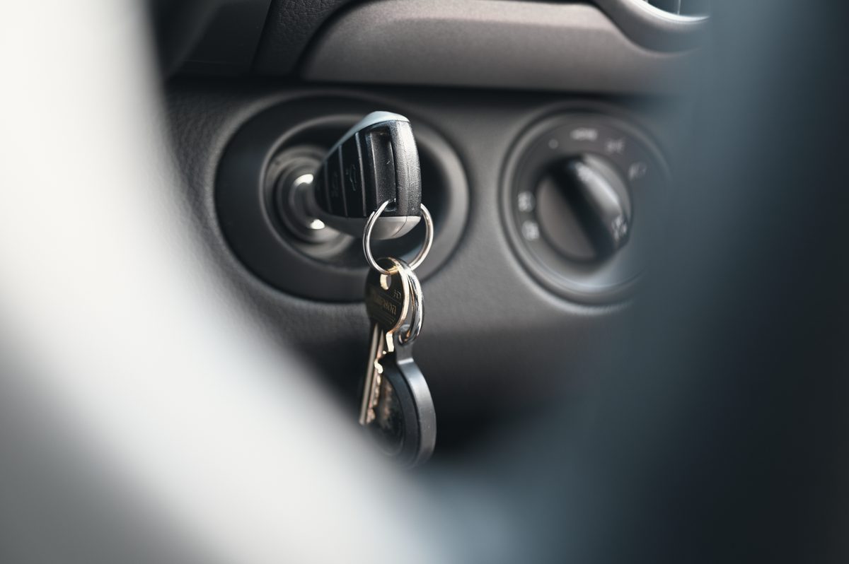 The key in the ignition of a Cayman, the dashboard soft behind.