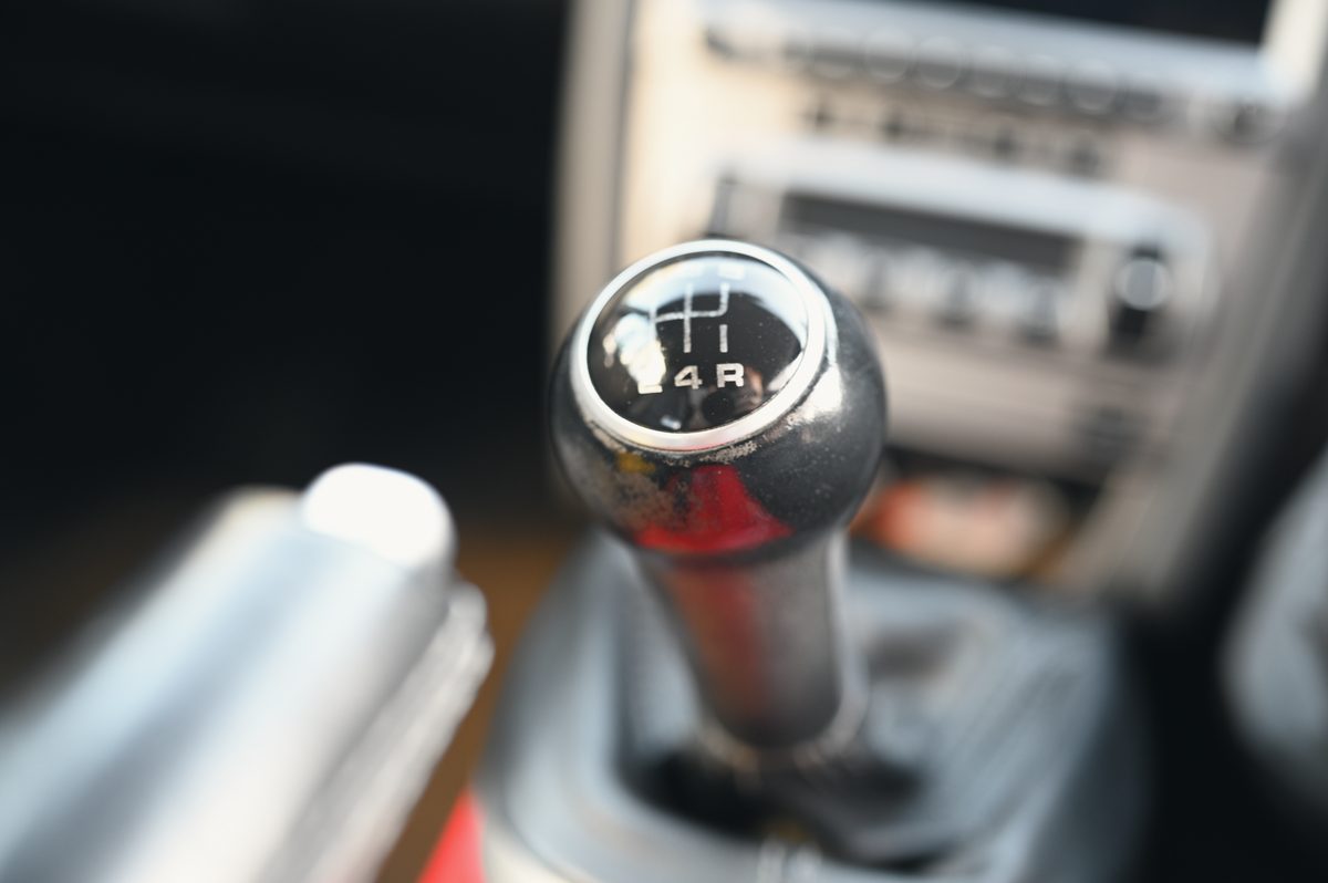 The gear knob, close, the centre console behind.