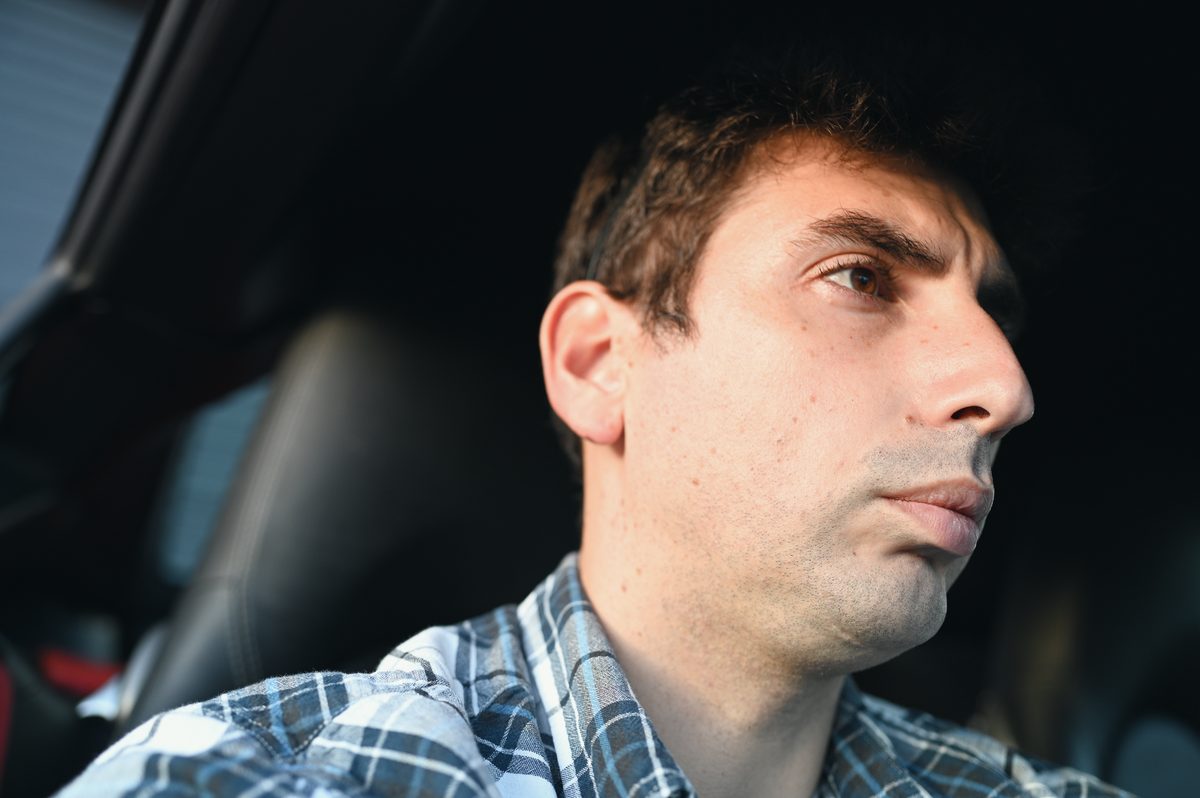 David in profile in the driver's seat, looking ahead.