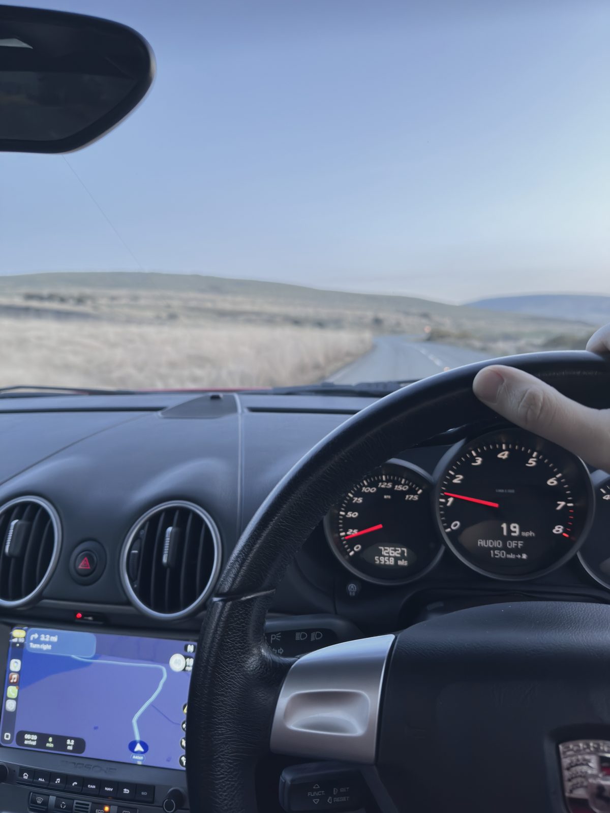 A hand on the wheel, the dials reading 19 mph, the road ahead.